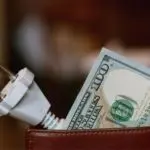 Electrical plug in a wallet with a one hundred-dollar bill, representing HVAC service costs at Chad's AC Direct.