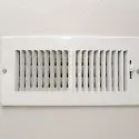 White wall-mounted air vent with horizontal slats, representing Chad's HVAC solutions for efficient home comfort.