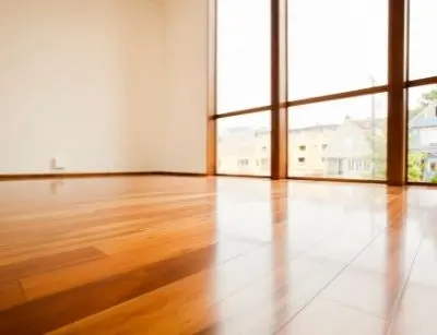 Hardwood flooring in a bright room with large windows, highlighting the importance of moisture protection to prevent warping and damage.