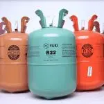 Refrigerant cylinders in orange, teal, and brown with labels for R22 and HVAC services at Chad's AC Direct.