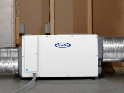 Whole-home dehumidifier unit by AprilAire, installed with ductwork, designed to reduce indoor humidity levels for enhanced comfort and efficiency.