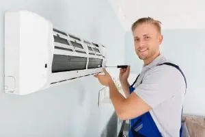 HVAC technician installing air conditioning unit, emphasizing Chris Wilson Plumbing & Heating's expertise in HVAC services.