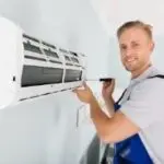 HVAC technician performing maintenance on an air conditioning unit, emphasizing professional service and expertise in air conditioning repairs.