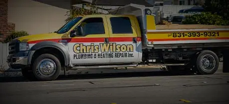 Chris Wilson Plumbing & Heating Repair Inc. service truck parked, featuring company logo and contact number, emphasizing professional plumbing and HVAC services.