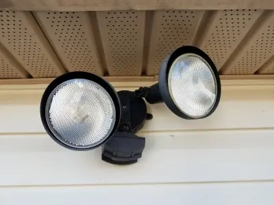Security lighting fixture with dual adjustable floodlights mounted on a wall, enhancing property safety and visibility at night.