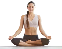 Woman meditating in a cross-legged position, promoting relaxation and wellness, relevant to air quality improvement and the PureAir ™ system by Lennox.
