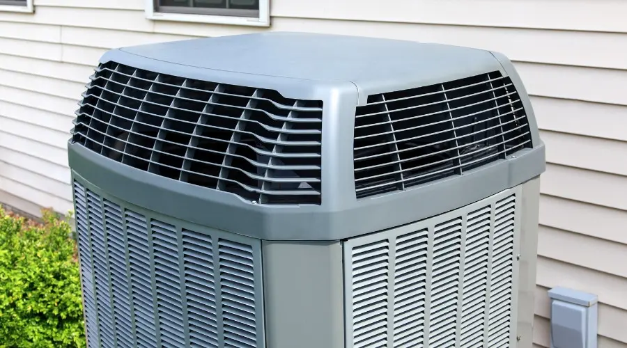 Air conditioning unit outside a home, showcasing central AC system design, relevant to choosing between central and ductless mini split systems.