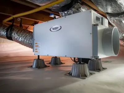 Dehumidifier unit installed in a home's crawl space, featuring ductwork and moisture control technology, relevant for managing indoor humidity levels.