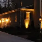 Residential building with warm exterior lighting and garage, showcasing architecture and landscaping by The Bosworth Company.