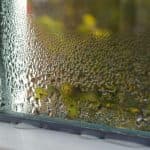 Window with condensation, highlighting humidity; ideal for understanding summer HVAC maintenance challenges.