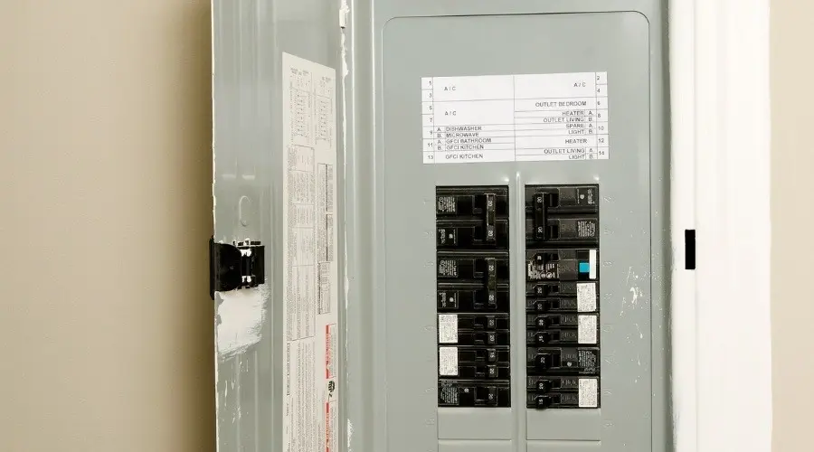 Electrical panel with circuit breakers and labeled outlets for home electrical system.