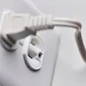 Close-up of electrical outlet and plug, showcasing The Meridian Company's efficient design for home energy savings.