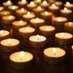 Numerous tealight candles in golden holders, creating a warm atmosphere for home comfort and indoor air quality improvement.