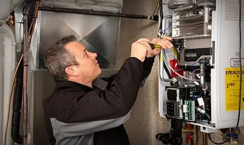 Technician repairing HVAC system, demonstrating expertise in heating and cooling services for home comfort solutions.