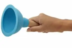 Hand holding a blue plunger, symbolizing tools for addressing blocked drains in plumbing emergencies.