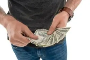 Person holding cash, emphasizing savings related to new boiler installation and energy efficiency.