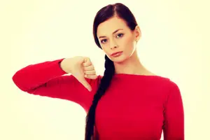 Woman in a red shirt giving a thumbs down gesture, expressing dissatisfaction, relevant to HVAC service quality concerns.