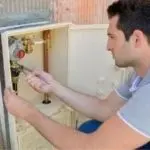Man performing maintenance on a plumbing system, emphasizing the importance of professional plumbing services for home safety and efficiency.