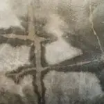 Water-damaged flooring showing cracks and stains, indicating potential structural issues related to plumbing problems.