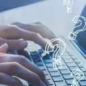 Hands typing on a laptop keyboard with question marks, highlighting City Plumbing's informative press release content.
