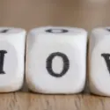 Close-up of wooden dice displaying letters "L," "O," and "V," illustrating City Plumbing's HVAC maintenance message.