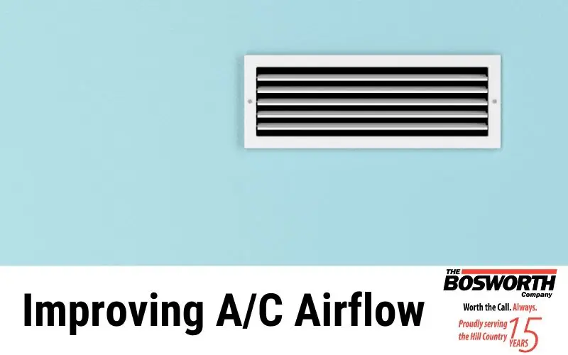 Air vent cover on light blue wall, labeled "Improving A/C Airflow" by The Bosworth Company, serving HVAC needs in Kerrville.