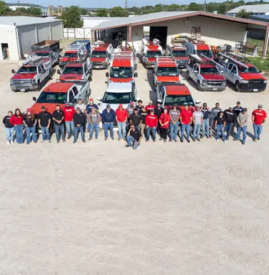 Team of technicians in front of service trucks at The Bosworth Company, highlighting their expertise in plumbing, heating, and air conditioning services in Kerrville, Texas.