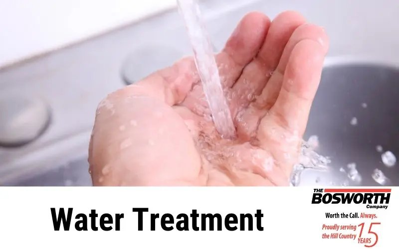 Close-up of a hand receiving clear water with The Bosworth Company's logo, showcasing water treatment services.