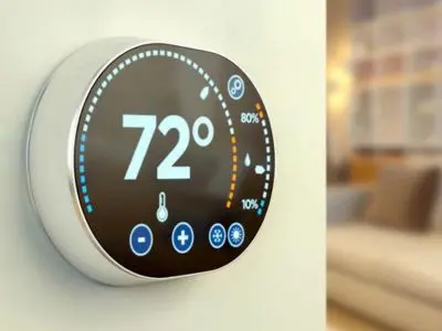Smart thermostat displaying temperature settings at 72&deg;F, illustrating energy-saving technology for optimizing home heating.