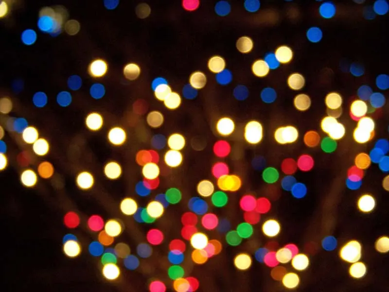 Colorful out-of-focus Christmas lights glowing in a festive display, evoking a cozy winter atmosphere.