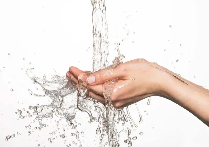 Hands catching falling water, illustrating plumbing solutions and water conservation techniques.