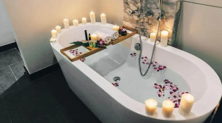 Luxury bathtub with candles and flower petals, creating a relaxing spa-like atmosphere for self-care and wellness.