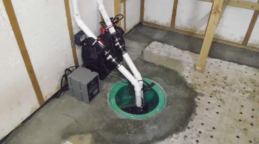 Sump pump installation by Scott Plumbing, showcasing sump basin, PVC piping, and moisture control setup.