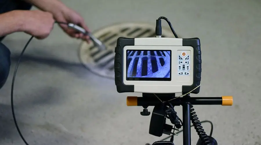 Operator using an inspection camera to assess a drainage system for Scott Plumbing maintenance services.
