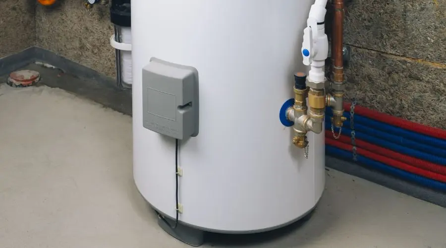 Water heater installation with plumbing connections and insulation in a basement setting, relevant to gas and electric water heater comparison.