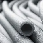 Black and white abstract foam tubing with intertwined shapes and texture, related to Quahog Plumbing services.