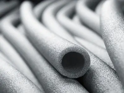 Foam pipe insulation tubes stacked together, emphasizing their role in preventing frozen pipes and burst plumbing during cold weather.