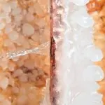 Frozen copper pipe with ice buildup and water dripping, illustrating potential plumbing issues during winterization.