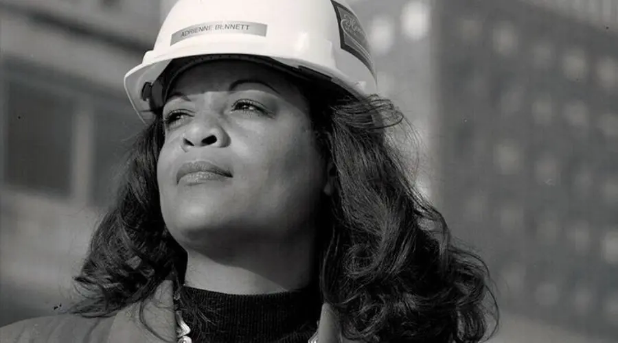 Woman in hard hat at construction site, highlighting plumbing professionalism linked to Quahog Plumbing services.