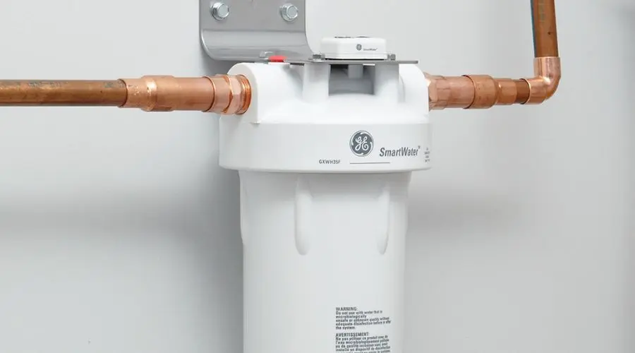 Water filtration system by GE SmartWater with copper piping, wall mount, and usage instructions for Quahog Plumbing services.