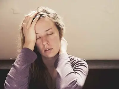 Woman experiencing discomfort and fatigue, illustrating symptoms of a gas leak such as headaches and dizziness, relevant to gas leak safety awareness.