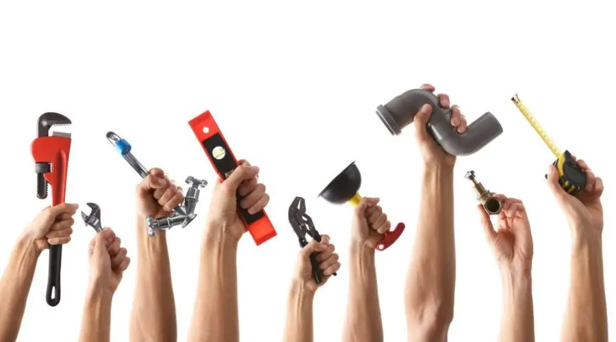 Several hands hold up various plumbing tools against a white background, including a wrench, a level, a pipe, a plunger, a pair of pliers, and a measuring tape.