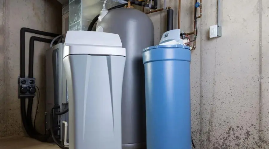 Water softener unit and pressure tank with plumbing connections at Quahog Plumbing service in Somerset, MA.