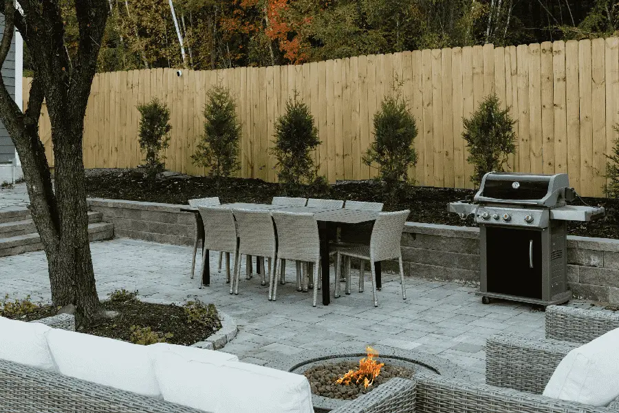 backyard table and grill beside a wooden fence
