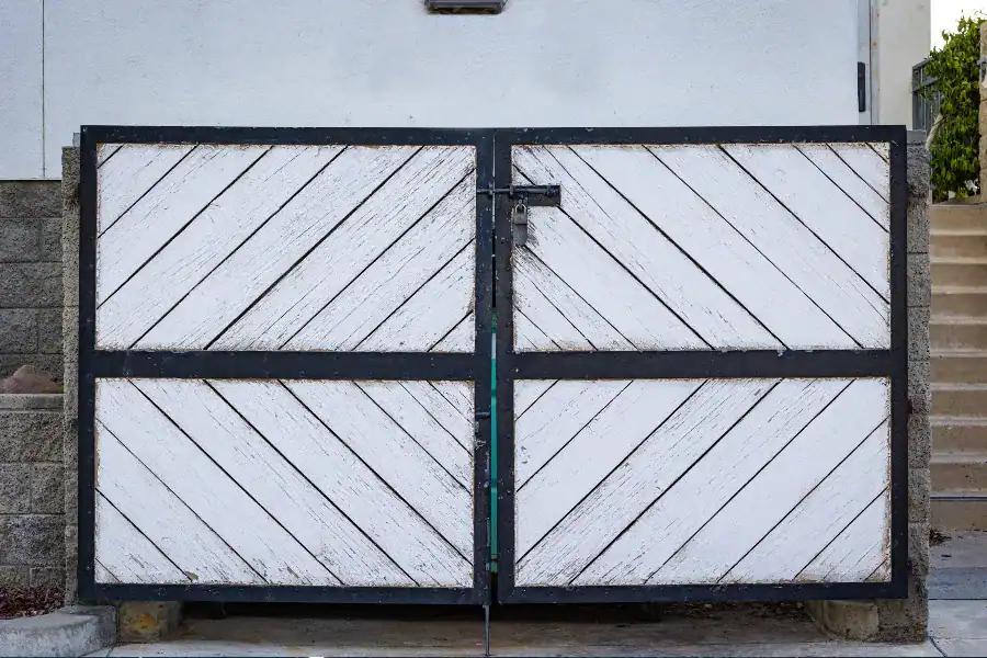 Residential double-leaf swing gate with wooden panels and metal frame