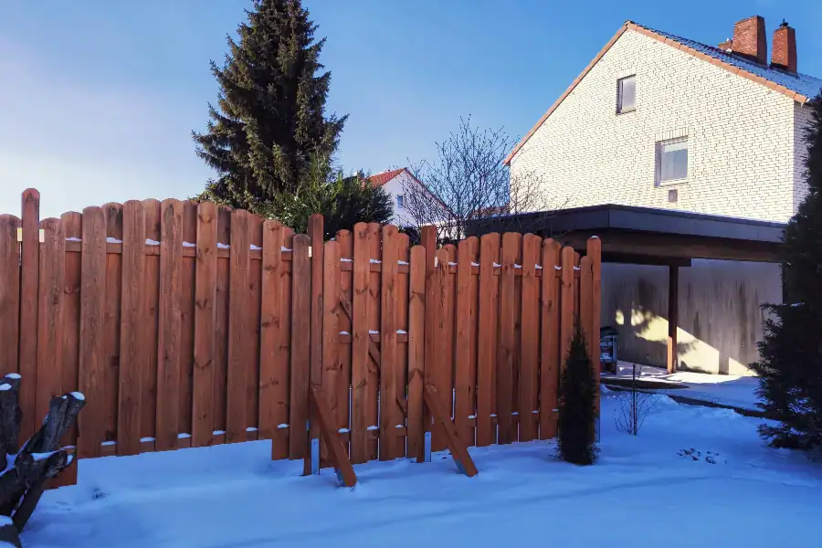 wood fence surrounded by snow