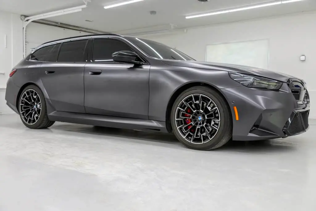Side view of a matte gray BMW inside Washington Auto Collision at 16811 E Sprague Ave, Spokane Valley, WA 99037.