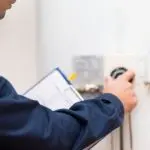Technician adjusting water heater thermostat during maintenance check for efficient operation and energy savings.