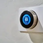 Modern smart thermostat displaying 63°F, highlighting energy efficiency for AirLux Heating & Cooling's HVAC solutions.