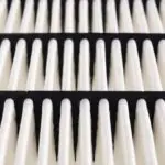 Air filter with vertical rows of alternating white and black layers, emphasizing HVAC maintenance for improved air quality.